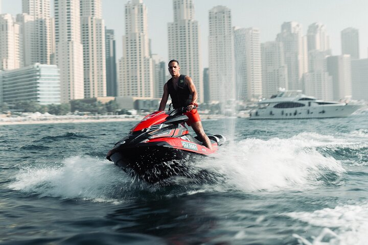 Experience the thrill of gliding over turquoise waters as you race past Dubai's iconic skyline and the stunning Ain Dubai creating unforgettable memories on your adventure.